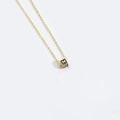 Minimalist gold chain necklace featuring a black cube pendant with the letter M - M