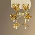 Detail of gold floral tassel earrings featuring triple-layered petals and pearl accents - 925 Silver Needle Style (34#)