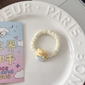 Détail d'un chouchou beige avec un ours en peluche 3D tenant une tasse de café bleue - Tasse à thé