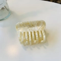 Detalle de pinza de pelo jaspeada con letras doradas de Barrette La France - Aprox. 8cm / Mármol Blanco Crema