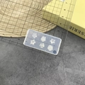 Detailed size measurement of a clear silicone flower nail mold with a ruler on top - #178 Flower