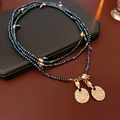Detail van vintage gouden ketting met donkerblauwe gefacetteerde kralen en munthangers - Meerlagige Lange Kralenstijl (WN319) / Goud-Donkerblauw