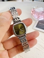 Detail of square green dial watch with silver strap near a perfume bottle - Silver Case Green Dial