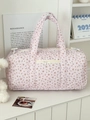 Detail einer gesteppten Reisetasche in Rosa mit Blumenmuster und Schleifenmotiven - Nebelrosa Lila