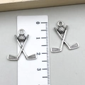 Silver metal ice hockey sticks and puck pendant charms shown with a size measurement ruler - Hockey Sticks and Puck