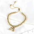 Adjustable gold beaded bracelet featuring a crystal-encrusted letter A pendant - Letter A