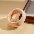 Dettaglio di un bracciale largo in resina con trama marmorea e ambra su sfondo minimalista - Stile Rotondo / Marmo Beige-Tondo
