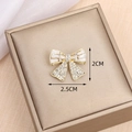 Elegant gold bow brooch with sparkling zircon stones in a 2.5cm by 2cm size - Bow