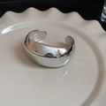 Detalle de brazalete ancho de plata pulida con diseño geométrico irregular - Brazalete Plateado de Superficie Ancha