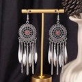 Detail of bohemian drop earrings with silver tassels and red beads on a display stand - S4292-1 Red Chain Tassel Earrings