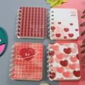 Set of four A7 mini spiral notebooks featuring red and white heart patterns and grids - Begonia
