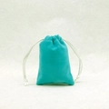 Macro view of velvet drawstring jewelry pouch in teal with white silk ribbons - Lake Blue