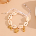 Handmade shell bracelet featuring gold starfish and dolphin charms with adjustable cord - White Rope Starfish Bracelet
