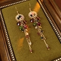 Detailed close-up of vintage flower earrings with colorful beads and long gold tassels - Gold-Multicolor