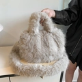 Detalle de bolso de peluche marrón claro con textura suave de piel sintética y asa - Color Té con Leche