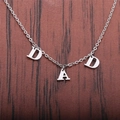 Collana in acciaio inossidabile lucido con ciondolo DAD su sfondo in legno scuro - PAPÀ / Argento
