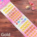 Macro shot of assorted golden gemstone stickers in shell, heart, and star shapes - Shell Series Gold