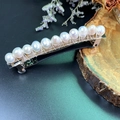 Close-up of white pearls with silver wire on a bohemian spring hair clip over wood - Pearl Hair Clip