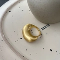 Anillo abierto dorado cepillado de diseño minimalista curvo sobre plato cerámico - Estilo Llamativo Cepillado / Dorado