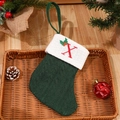 Dark green cable knit Christmas stocking featuring embroidered letter X and holly leaves - Letter X