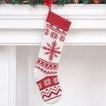Classic red and white knitted Christmas stocking with snowflake patterns hanging on fireplace - Snowflake Style