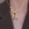 Elegant gold-tone fan-shaped necklace with central zircon and beaded charm detail - Gold Without Beads
