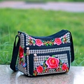 Close-up of ethnic floral embroidery and metal zipper on black canvas shoulder bag - Red Rose