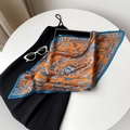 Detail of pleated satin square scarf with orange paisley patterns and jagged edges - Orange Blue Paisley