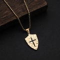 Detail of gold shield pendant with textured surface and black cross on wood block - Gold Black (Gold Pendant Black Cross)