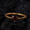 Macro shot of twisted gold band ring with heart-shaped red garnet stone on dark rock - Natural Garnet (LR267) / Gold