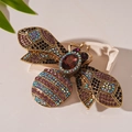 Dettaglio macro della spilla a forma di ape dorata vintage con cristalli e strass viola - Spilla Ape con Strass Viola