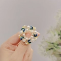 Close-up of vintage wreath brooch with colorful enamel leaves and white pearls - Pearl Wreath