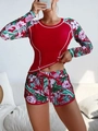 Detail of red long-sleeve rash guard with tropical floral print and matching swim shorts - Red