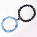 Close-up of magnetic heart clasp connecting blue and black crown stone beaded bracelets - Weathered Agate And Lava Stone