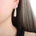 Eleganti orecchini a goccia argento e bianco crema con design bicolore indossati - Color Acciaio