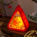 Macro shot of red Christmas lantern with Santa pattern on a wooden festive table - Triangle Lantern-Red Santa
