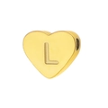 Macro detail of heart-shaped gold titanium pendant with engraved letter L on mirror finish - Letter L