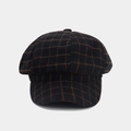 Detail of vintage wool tweed texture on a black and brown plaid newsboy cap - Black