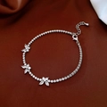Dettaglio di bracciale a farfalla in argento con zirconi su tessuto di seta rossa - Argento