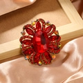 Vintage gold alloy flower brooch with large faceted red crystal and rhinestone accents - Red