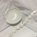 Macro view of polished white mother of pearl oval beads in a shell ceramic dish - 18*25 Oval