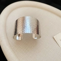 Macro detail of silver wide cuff bangle with hammered metal texture and irregular wavy edges - Silver Hammered Surface