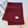 Thick burgundy knit scarf for winter featuring a beige woven brand label in wine red color - Angola Red