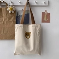 Detailansicht der cremefarbenen Canvas-Tragetasche mit süßem braunem Bären-Motiv - Kleiner Runder Bärenkopf Beige
