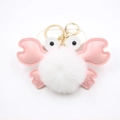 Detail of cute crab pompom keychain with white plush ball and pink faux leather claws - White