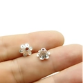 Primer plano de pequeñas cuentas de flores plateadas para hacer joyas artesanales - Plata Brillante