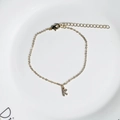 Detail of 18K gold-plated initial K bracelet with sparkling cubic zirconia on a white plate - Letter K