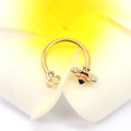 Makroaufnahme eines goldenen Bienen Hufeisenrings mit Kristallen auf einer Blume - Gold