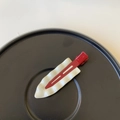 Close-up of a red and white wavy leaf hair clip on a minimalist black display plate - White / Red Clip