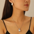 Conjunto de joyas minimalista plateado con collar y pendientes lucido por una modelo - Conjunto de pendientes y collar / Plateado